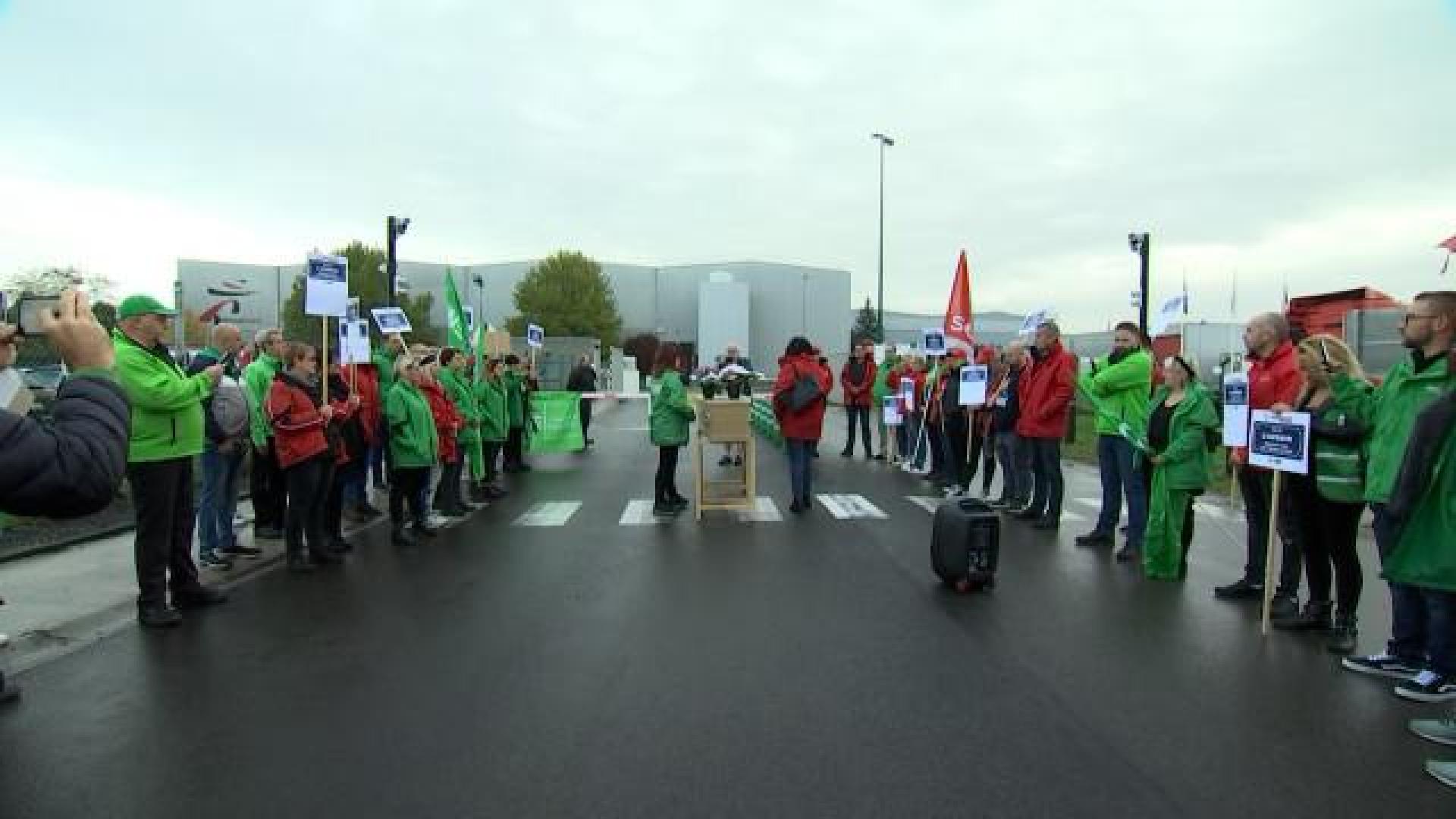 Dépôt d'une gerbe de fleurs par les travailleurs Mestdagh chez Intermaché à Villers-le-Bouillet