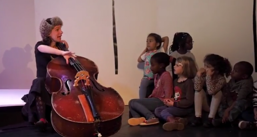 enfants écoutant une artiste jouant du violoncelle